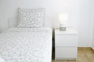a bedroom with a bed and a white nightstand at Host Wise - Sweet & Sunny Flat - Ace Location in Quarteira