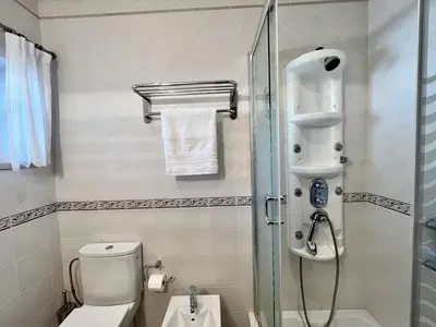 a bathroom with a toilet and a glass shower at Quarteira Classic 1 With Pool by Homing in Quarteira