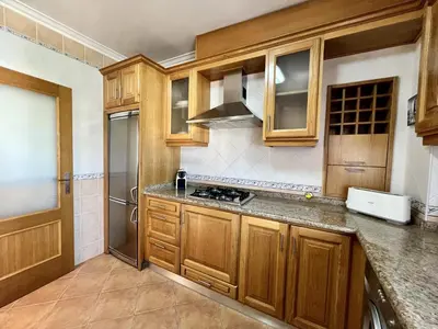 a kitchen with wooden cabinets and a stove at Quarteira Classic 1 With Pool by Homing in Quarteira