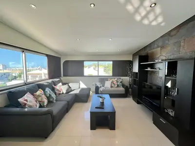 a living room with a couch and a tv at Quarteira Classic 1 With Pool by Homing in Quarteira