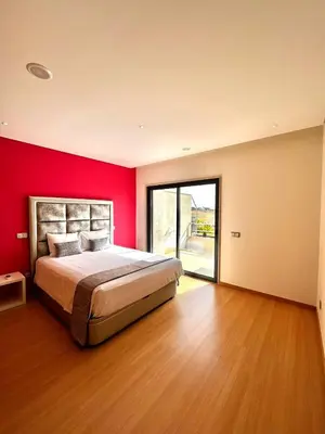 a bedroom with a large bed with a red wall at Funtastic Villa With Pool in Albufeira