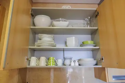 a cabinet filled with plates and bowls and dishes at Quinta da Barracuda Prime Sea View Apartment in Albufeira