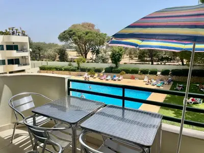 a balcony with a table and chairs and an umbrella at Kasa Joly Albufeira By Calyferias in Albufeira