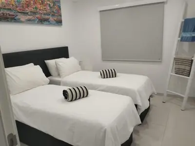 two beds with striped pillows on them in a room at Vila Golf in Vilamoura