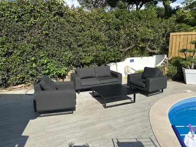 two lounge chairs and a table next to a pool at Vila Golf in Vilamoura