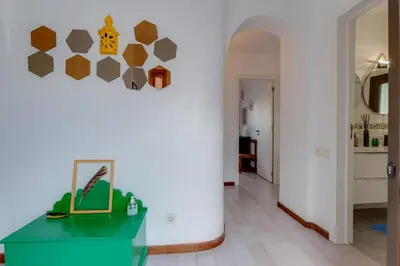 a living room with a table and a wall with a hexagonal wall at CASA NINI - Apart para 6 com AC e a 100 m da praia Mónica Isabel in Albufeira