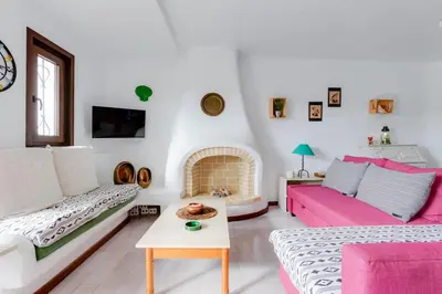 a living room with a couch and a fire place at CASA NINI - Apart para 6 com AC e a 100 m da praia Mónica Isabel in Albufeira