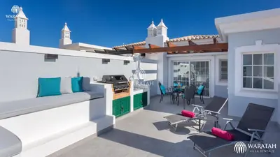 a patio with chairs and a grill on a house at Apartment Kairi in Vale do Lobo