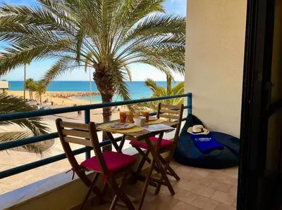 a table and chairs on a balcony with a palm tree at Infante Sagres by FHR1º linha da praia in Quarteira