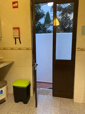 a door to a bathroom with a green stool next to it at The Tiles House in Faro