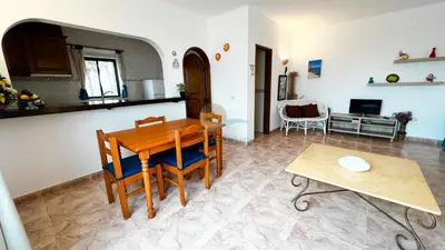 a kitchen and living room with a table and chairs at Albufeira Calipto by Sunny Deluxe in Albufeira