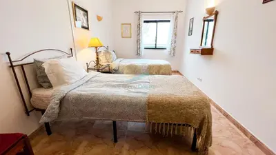 a bedroom with two beds and a chair at Albufeira Calipto by Sunny Deluxe in Albufeira