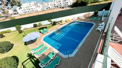 an overhead view of a swimming pool with chairs and umbrellas at Albufeira Calipto by Sunny Deluxe in Albufeira