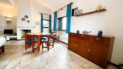 a living room with a table and chairs and a fireplace at Albufeira Calipto by Sunny Deluxe in Albufeira