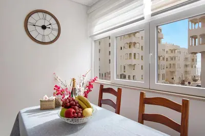 a living room with a flat screen tv on a wooden cabinet at Apartamento Peron in Quarteira