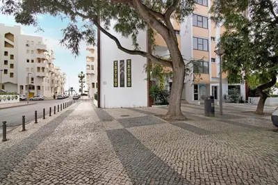 a cobblestone street with trees and buildings at Apartamento Peron in Quarteira