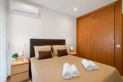 a bedroom with a large bed with a large window at Apartamento Peron in Quarteira
