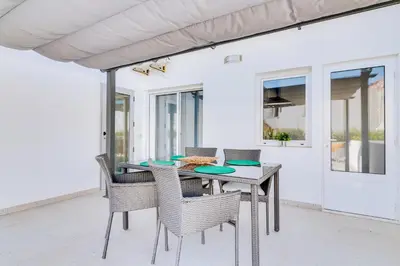a dining table and chairs on a patio at Marina Star Guesthouse in Faro