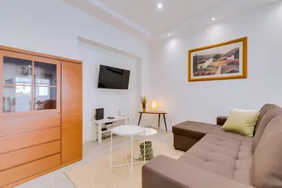 a living room with a couch and a tv at Marina Star Guesthouse in Faro