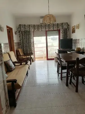 a living room with a couch and a table and chairs at Leonel Barcelos in Quarteira