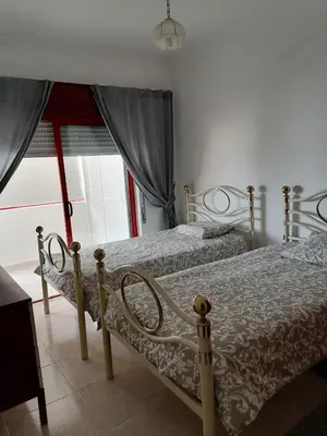 a bedroom with two beds and a window at Leonel Barcelos in Quarteira