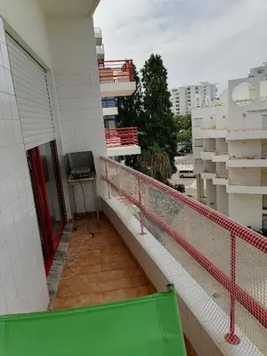 a balcony of a building with a desk on it at Leonel Barcelos in Quarteira