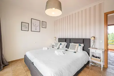 a bedroom with a large bed with white sheets and pillows at BeGuest Copacabana Vilamoura Apartment in Quarteira