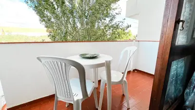 a small white table and two chairs on a porch at Apartamentos Oura AreiaSol by Sunny Deluxe in Albufeira