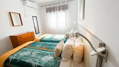 a bedroom with a bed with a green blanket at Apartamentos Oura AreiaSol by Sunny Deluxe in Albufeira