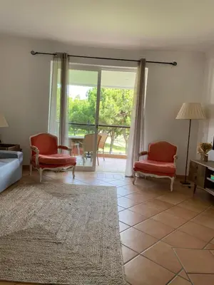 a living room with red chairs and a large window at House of Rising Sun in Quarteira