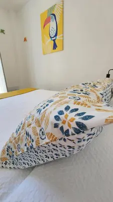 a bed with a comforter and a pillow on it at Casa do Sol Faro in Faro