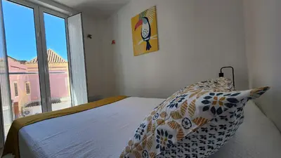 a bedroom with a bed with a pillow and a window at Casa do Sol Faro in Faro