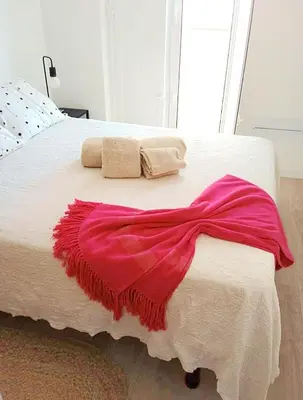 a white bed with a red blanket on it at Casa do Sol Faro in Faro