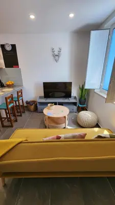 a living room with two beds and a table at Casa do Sol Faro in Faro
