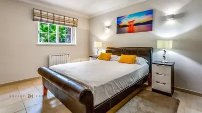 a bedroom with a large bed with yellow pillows at Luxuosa moradia V5 em Quarteira - Greice Homes in Quarteira