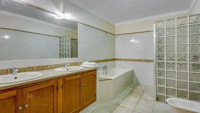 a bathroom with two sinks and a bath tub and a mirror at Luxuosa moradia V5 em Quarteira - Greice Homes in Quarteira