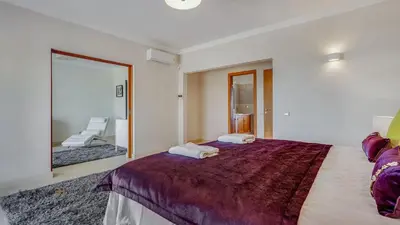 a bedroom with a large bed and a large mirror at Luxuosa moradia V5 em Quarteira - Greice Homes in Quarteira