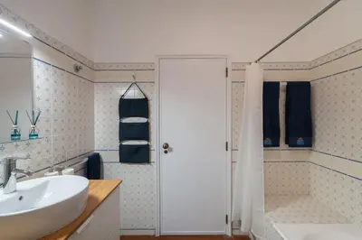 a bathroom with a white sink and a shower at SILCHORO - Estúdio remodelado com AC e piscina in Albufeira