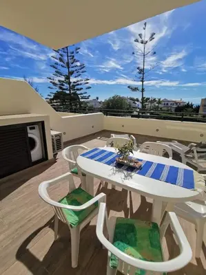 a balcony with a table and chairs on a roof at Santa Fé in Albufeira