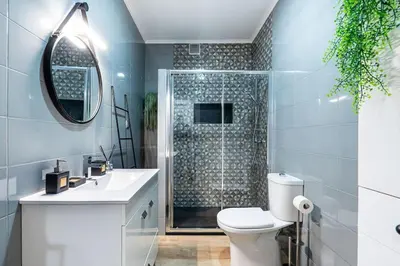 a bathroom with a shower and a toilet and a sink at Faro Center with AC & WiFi in Faro