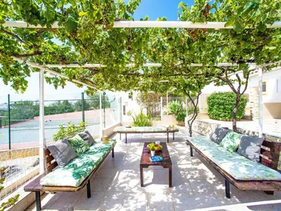 a patio with couches and a table under a tree at Holiday Home Eugênia by Interhome in Paderne