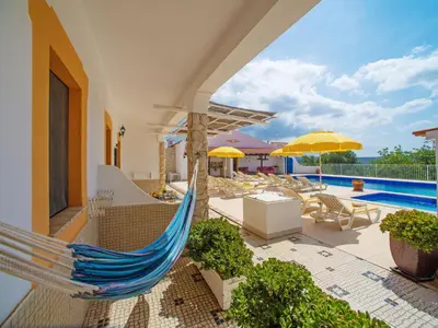 a patio with a hammock and a swimming pool at Holiday Home Eugênia by Interhome in Paderne