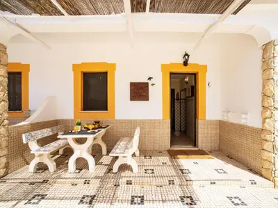 a patio with a table and chairs under a tree at Holiday Home Ana by Interhome in Paderne