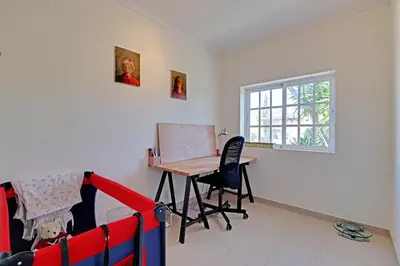 a room with a desk and a table and a window at Casa de Apra by Portucasa in Loulé