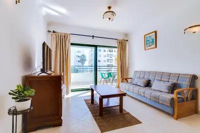 a living room with a couch and a tv at AL - Apartamento Pérola in Quarteira