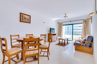 a living room with a table and chairs at AL - Apartamento Pérola in Quarteira