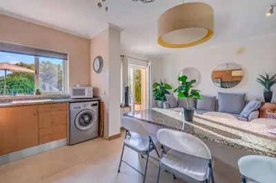 a kitchen and living room with a table and chairs at Place in the sun - Free out door Jacuzzi - BY BEDZY in Albufeira