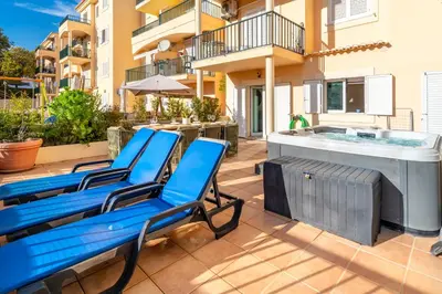 a patio with blue chairs and a hot tub at Place in the sun - Free out door Jacuzzi - BY BEDZY in Albufeira