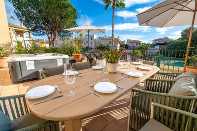 a wooden table with plates and wine glasses on a patio at Place in the sun - Free out door Jacuzzi - BY BEDZY in Albufeira