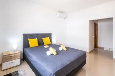 a bedroom with a blue bed with yellow pillows at Villa Bahia by Algarve Vacation in Albufeira